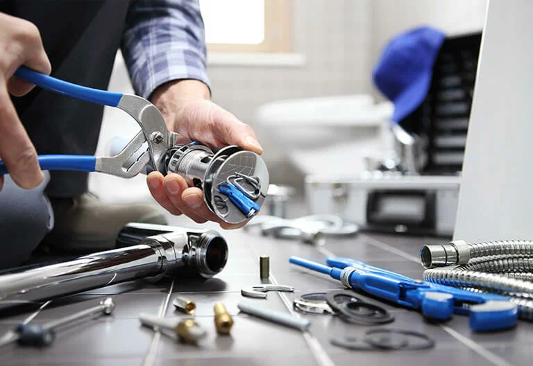 Technician repairing a plumbing fixture with professional tools in Gibsonton