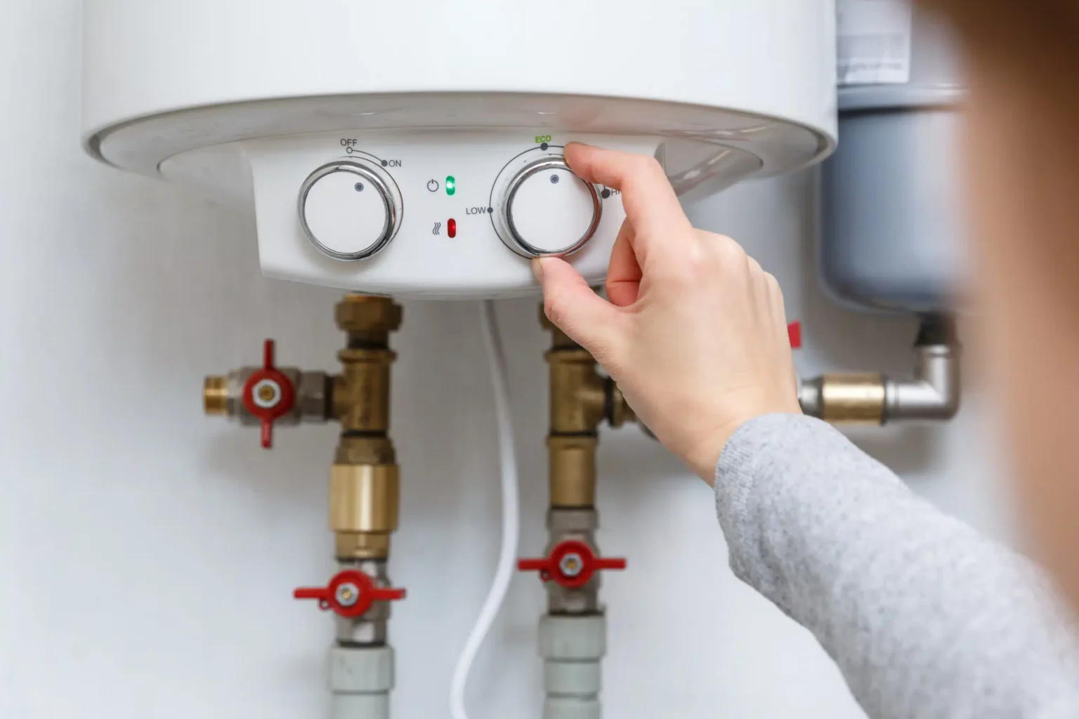 Homeowner adjusting the temperature controls on a water heater in Gibsonton
